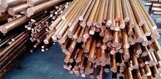 Bundles of copper round bars stacked in industrial storage area